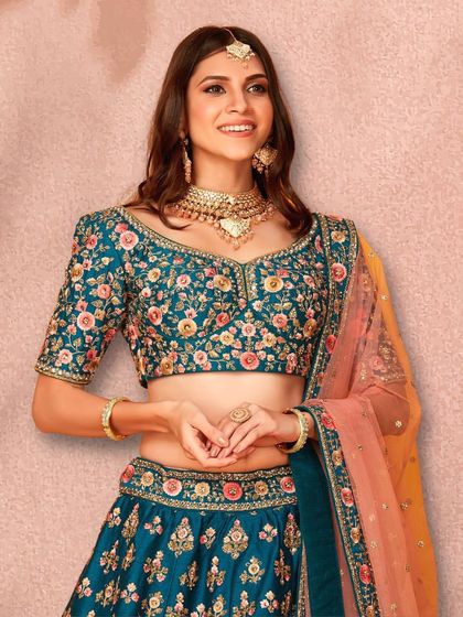 This teal lehenga with colorful floral embroidery is a fascinating and unique design, perfect for a guest who wants to stand out.