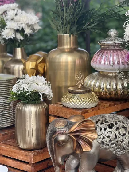 A close-up of our intricate and elegant decor elements, including brass vases and a silver elephant statue, which add a touch of luxury to our setups.