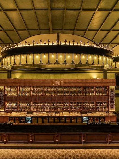 A direct look at the main bar, the centerpiece of the entire project. The three large, illuminated canopies create a sense of scale and drama, drawing the eye and anchoring the space. The back bar is designed for both display and function.