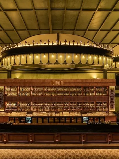 A direct look at the main bar, the centerpiece of the entire project. The three large, illuminated canopies create a sense of scale and drama, drawing the eye and anchoring the space. The back bar is designed for both display and function.