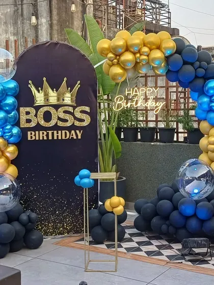 A bold 'Boss Birthday' theme with a black, blue, and gold balloon arch, a custom backdrop, and a large crown detail.