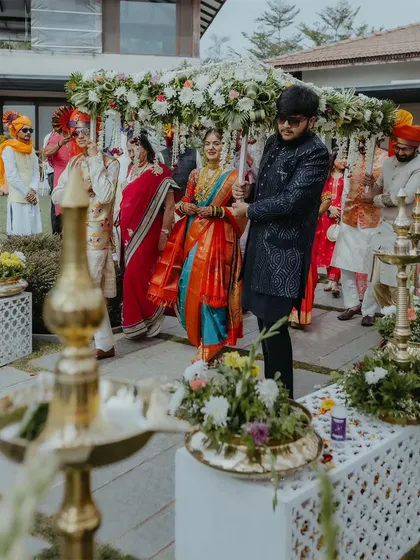 The bride's entrance under a 'phoolon ki chadar' (floral canopy), a classic and beautiful moment in an Indian wedding.