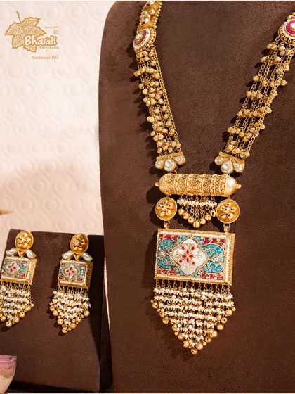 Inspired by the treasures of the sea, this long antique set features serene turquoise and lustrous pearls. The intricate Meenakari work on the 22ct gold pendant creates a piece of royal serenity and timeless grandeur.