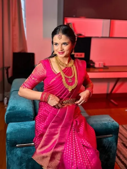 This client looks stunning in a bright pink Kanchivaram saree, paired with a matching blouse for a bold, monochromatic look.