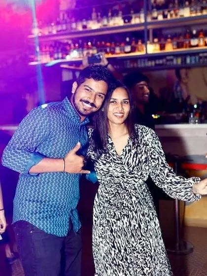 This couple is having a great time dancing and posing for a picture during the party.