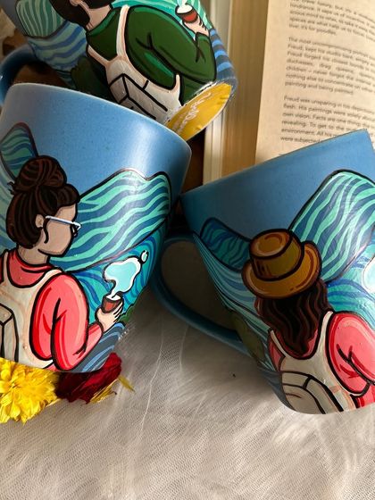 A side-by-side comparison of the two female versions of the 'Wanderlust' mug, one with glasses and one with a hat.