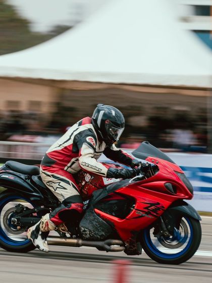 A rider on a red Suzuki Hayabusa shows off its power, a testament to the bike's enduring legacy in drag racing.