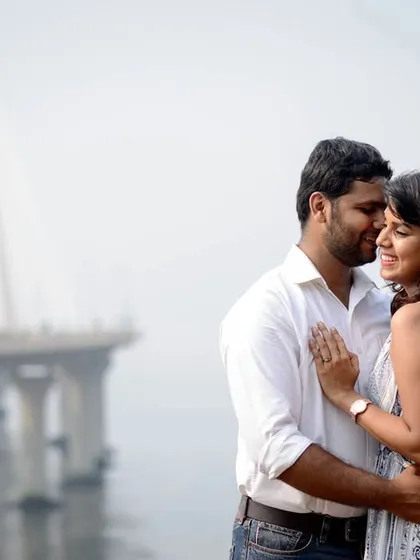 Whispering sweet nothings with the Bandra-Worli Sea Link in the background. This pre-wedding photo captures a classic romantic moment in an iconic Mumbai location.