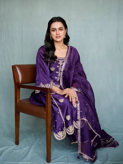 Shraddha Srinath looks radiant in this deep purple salwar suit for her movie promotions. The gold embroidery provides a rich contrast, making it a regal and elegant look for any formal occasion.