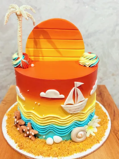A beautiful beach-themed cake with a sunset gradient, edible sand, and fondant decorations like a palm tree, sailboat, and seashells.
