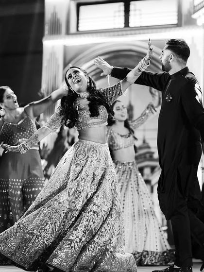A black and white photo capturing the movement and joy of a couple's dance. The spin shows off the bride's lehenga beautifully, a detail we always consider in our choreography.