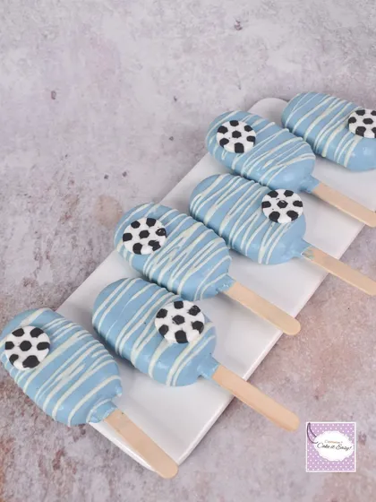 Football-themed cakesicles with a blue and white drizzle.