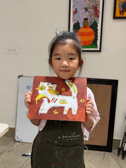 Exploring the beautiful traditions of Indian folk art is one of my favorite things to do with the kids. Here, a young artist proudly shows off her amazing cat painting inspired by these rich styles.