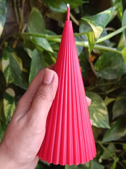 A hand-held view of the red ribbed Christmas pillar candle.