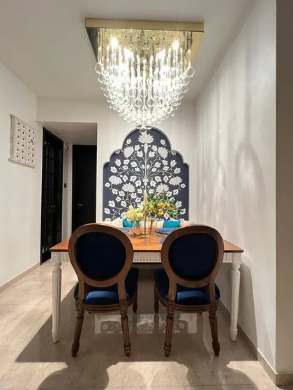 A full view of a client's dining space, featuring my classic dining table and chairs, paired with a custom tufted bench.