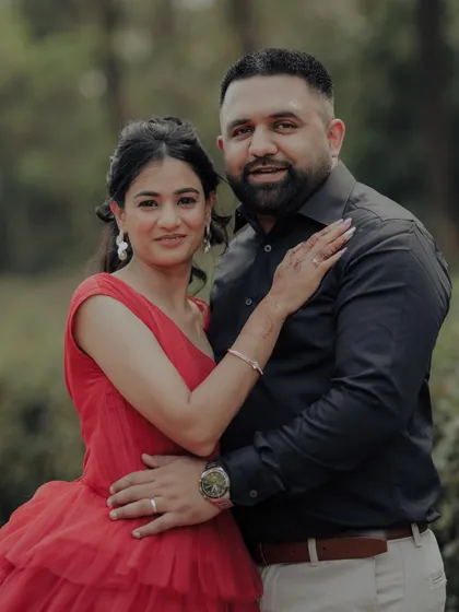 A classic portrait from an engagement shoot in a lush Pune garden. The woman's striking red gown and the couple's confident pose create a timeless and elegant image, showcasing a more formal and styled approach to pre-wedding photography.