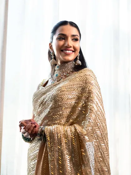 A happy, candid shot. The makeup looks fresh and radiant, perfect for a long day of wedding festivities.