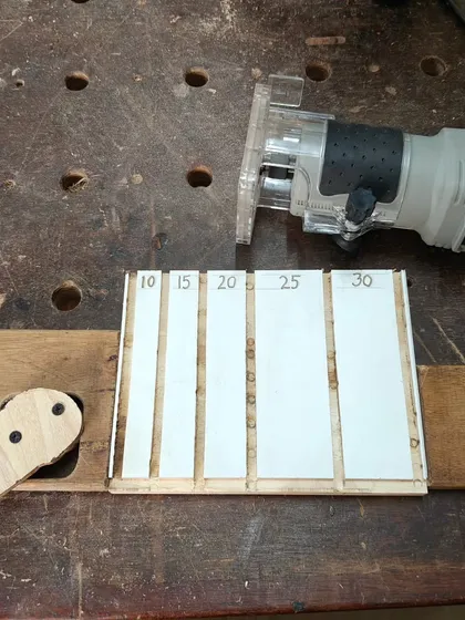 A cam-based clamping system I built for use with my router. This simple jig holds workpieces securely for precise carving tasks, like making the slots in this nail sorting tray.