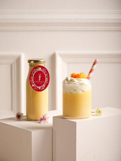 Our vibrant mango smoothie, a taste of pure summer, served in a glass and ready to-go in a bottle.