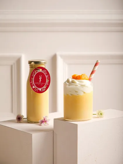 Our vibrant mango smoothie, a taste of pure summer, served in a glass and ready to-go in a bottle.