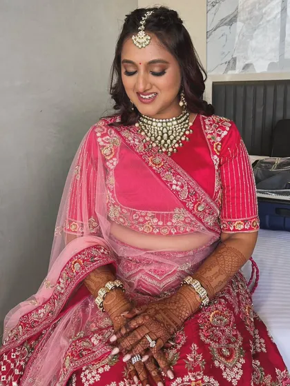 A classic bridal look with golden hues on the eyes and a bold red bindi. This style is perfect for a traditional wedding ceremony.