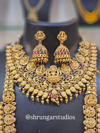 This is a full, opulent temple jewellery set with intricate carvings of deities, perfect for a traditional wedding ceremony.