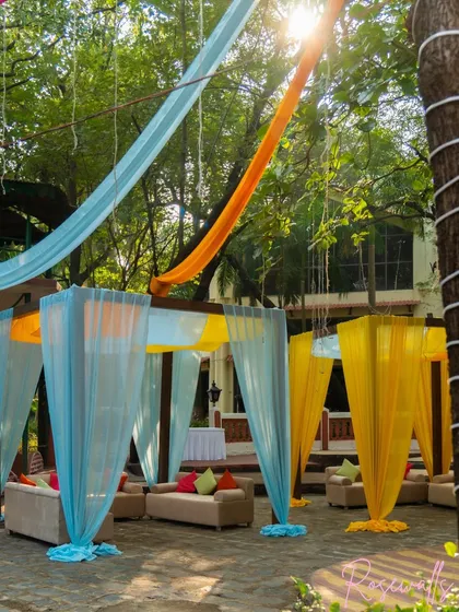 We created cozy and colorful lounge areas using cabanas draped in bright yellow and blue fabric, perfect for guests to relax and chat.