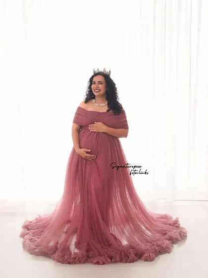 This portrait showcases the full, beautiful train of the mauve gown against a clean white backdrop.