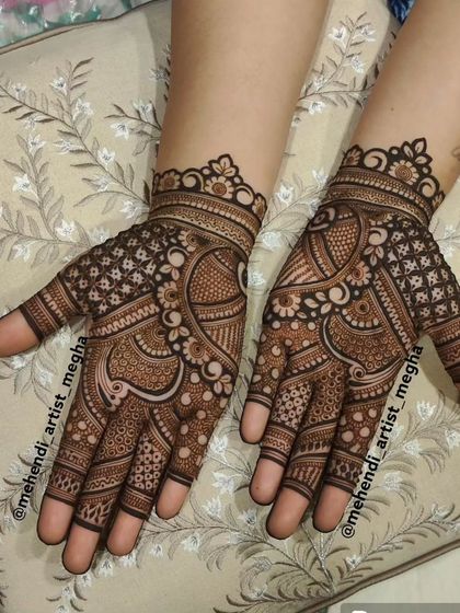 A rich and complex design that combines florals, paisleys, and geometric checks for a classic full-hand mehendi look.