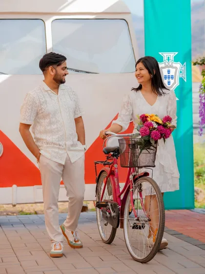 A sweet and casual shot with a bicycle, evoking the charm of a European town. The couple's relaxed interaction and the colorful backdrop make for a delightful and candid pre-wedding photo.