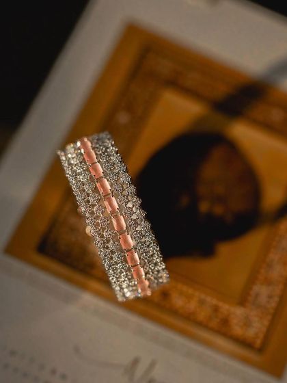 A creative shot of a bridal bracelet resting on a decorative box, with dramatic lighting highlighting its intricate details.