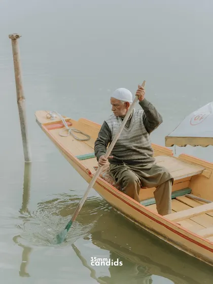 A local man rows his shikara on Dal Lake. Capturing these details of daily life adds depth and authenticity to a destination shoot.