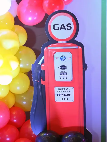 A fun, thematic prop of a vintage gas pump, adding to the immersive experience of the Ferrari race car party.
