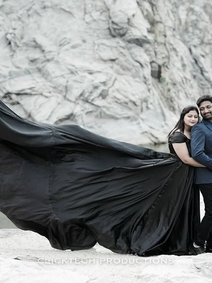 A dramatic pre-wedding photo taken at a quarry, where the bride's long black gown flows majestically in the wind, creating a powerful and artistic image.