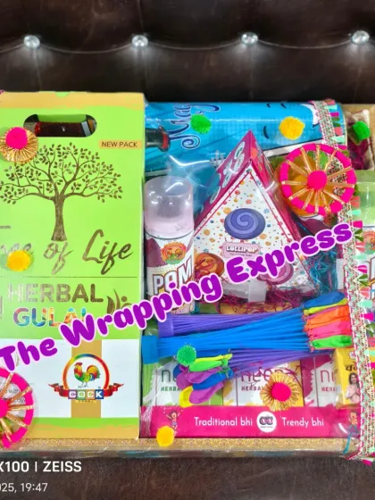 A complete Holi hamper on a tray, including herbal gulal, water balloons, and color sprays.