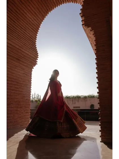A silhouette of the bride, Samriddhi, against the sun in a beautiful brick archway in Morocco. The light, shadow, and architecture come together to create a powerful and artistic portrait.