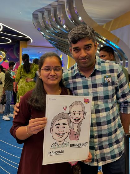 A couple holding their caricature at a family party. It's a great way for guests to interact and get a unique souvenir.