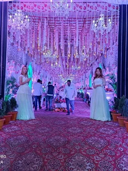 To create a grand welcome for your guests, I can arrange for elaborate entrance decor like this. The passage is lined with floral arrangements and chandeliers, and can include welcome hosts to greet your guests.