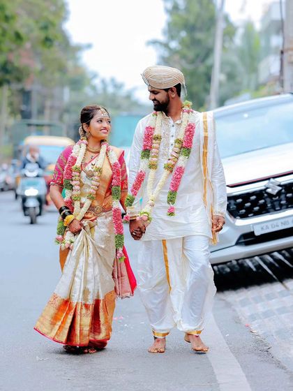 Taking the celebration to the streets. A candid shot of the newly married couple walking together after the ceremony, still adorned in their garlands.