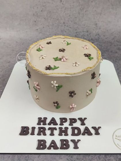 A unique chocolate floral cake with a vintage feel. The muted brown tone is decorated with tiny, delicate piped flowers.