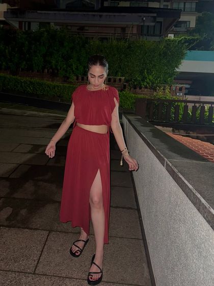 A red co-ord set with a crop top and a thigh-high slit skirt. This is a great vacation outfit for a dinner or a night out.