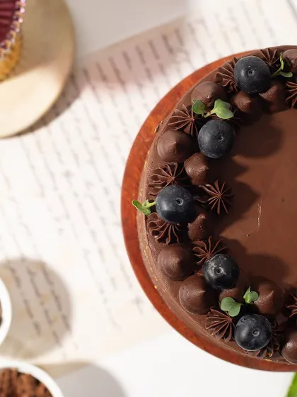 An overhead view of the Winter Berry Cake, showing the beautiful arrangement of fresh blueberries and chocolate frosting swirls.