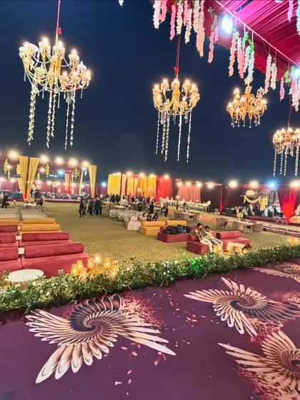 A low-angle shot across a beautifully patterned carpet, showing the extensive lounge seating and hanging chandeliers.