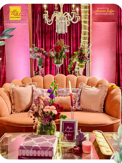A close-up of a cozy and elegant seating arrangement. The scalloped velvet sofa, adorned with plush cushions and surrounded by fresh flowers, provides a perfect photo opportunity and a comfortable spot for guests.