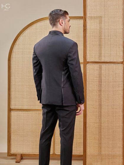 A view of the back of this uniquely designed black suit, showing how the clean lines are maintained for a sharp and tailored look from every angle.