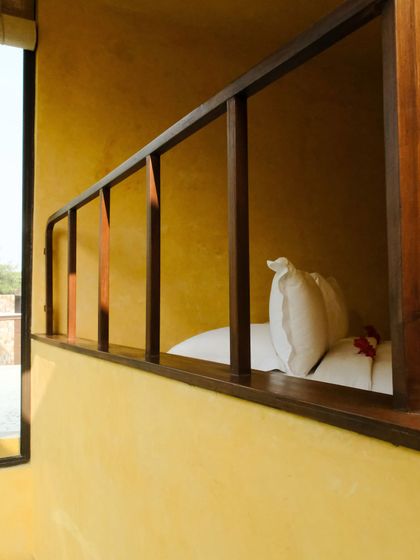 A view into a suite from the outside, showing the cozy bed nook and the seamless connection to the outdoors.