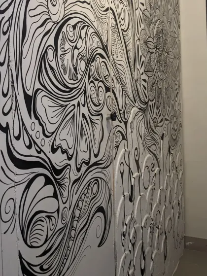 This finished mandala mural was created on a wall that also includes a door, integrating the artwork seamlessly into the architecture of the room. The flowing organic lines and detailed patterns wrap around the space, making it feel truly custom.