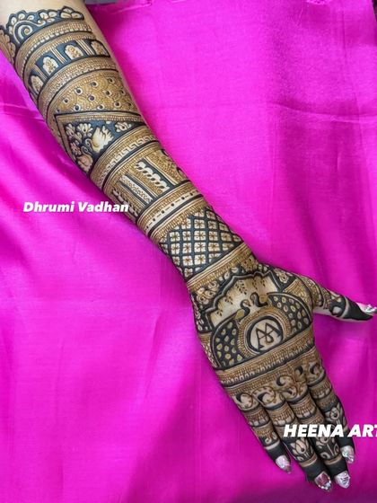 The full arm view of a bridal mehendi, showcasing bands of different traditional patterns like elephants and jaali work.