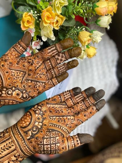 The same bridal palms from a different angle, with flowers in the background to complement the occasion.