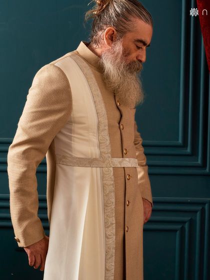 A side profile of the beige sherwani, highlighting the clean lines and the elegant drape of the attached panel. It’s a subtle detail that makes a significant impact.